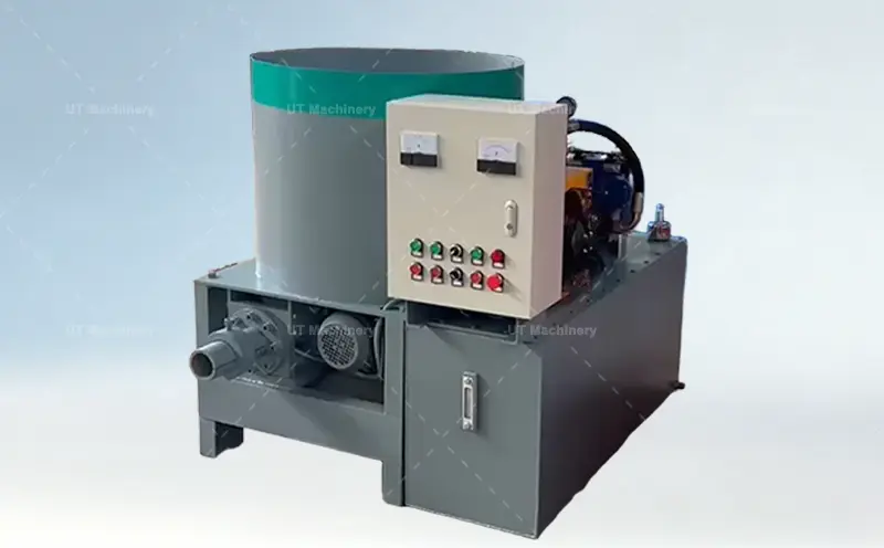 Máquina briquetadeira industrial de casca de arroz com um grande funil de borda verde, um painel de controle externo branco com dois medidores analógicos e oito botões coloridos, e uma saída frontal de descarga de briquetes.