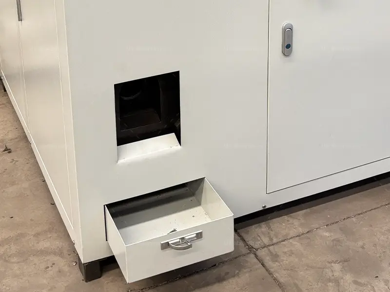 Calha de descarga de blocos cilíndricos acabados apresentando uma gaveta de coleta integrada para recuperar fluidos de corte residuais e emulsão de refrigeração.