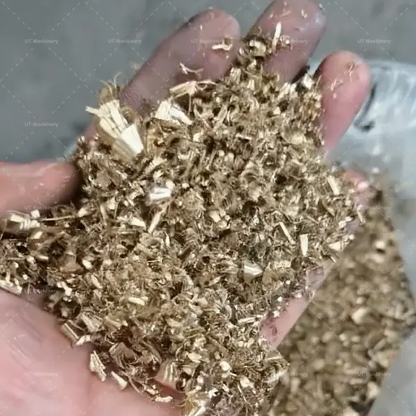 Prime plano de cavacos de cobre soltos e úmidos embebidos em fluido de corte de uma oficina de usinagem.