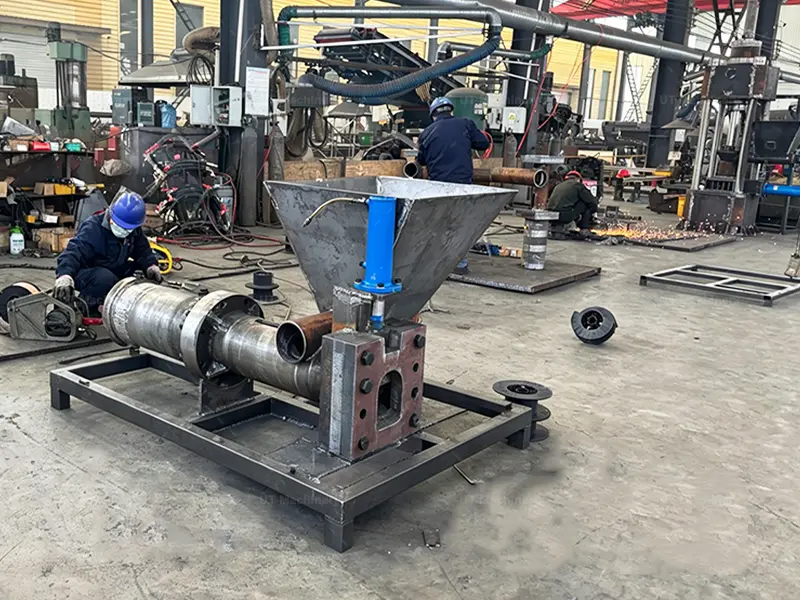 Integração do sistema de pistão hidráulico interno e do funil de alimentação de material durante o processo de fabricação da prensa briquetadeira de sucata metálica.