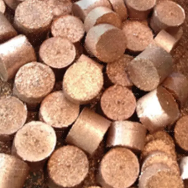 Uma pilha de briquetes cilíndricos terminados de pequenos cavacos de latão, prontos para reciclagem metalúrgica e fusão.