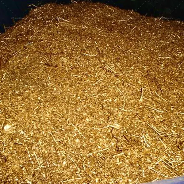 Cavacos de latão dourado bruto e resíduos metálicos industriais acumulados para reciclagem com redução de volume.